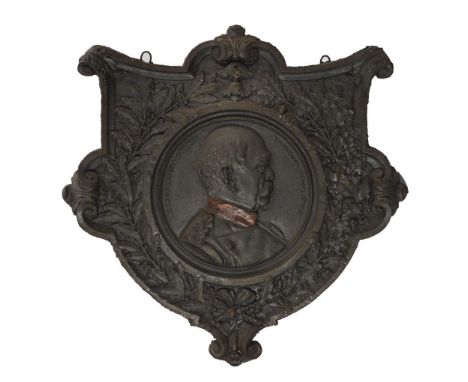 Gusseisernes Wandwappen mit Bismarck-Bildnis. Um 1900.             Gusseisen mit originalen Hängeösen, anthrazitfarben und ro