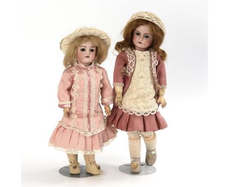 2 Mädchenpuppen mit rosa Kleidern. Heinrich Handwerck. Beide gemarkt. Um 1900.             Biskuitporzellan, Masse. L 43/48 c