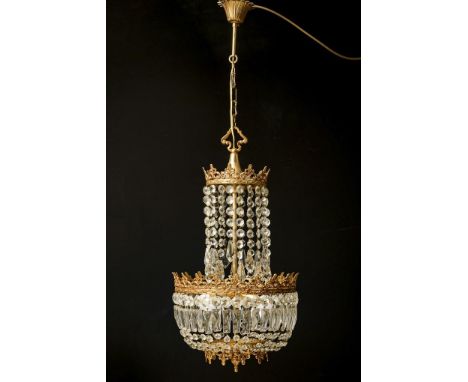 Eleganter Deckenlüster. Mitte 20. Jh.             Messing, Prismenbehang. L ca. 100 cm, Ø ca. 32 cm.             4-flammige, 