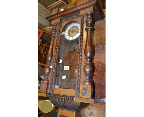 An early 20th Century walnut Vienna clock, Roman numerals, white enamel dial.