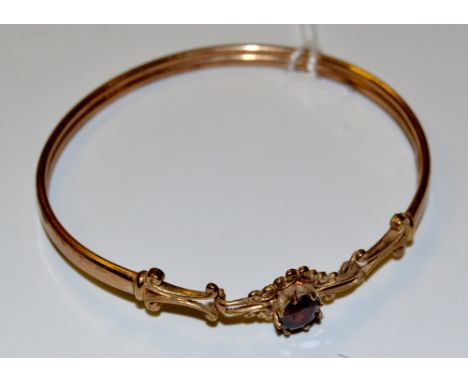 A 9ct gold bangle, with garnet, 6.2g