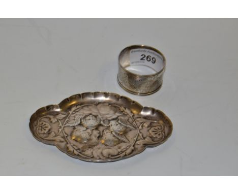 A silver napkin ring, engraved and chased with foliate scrolls,Chester 1907;  a silver quatrefoil trinket dish, embossed with