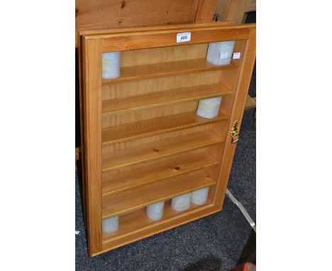 A pine six shelf collectors wall hanging cabinet, glazed door