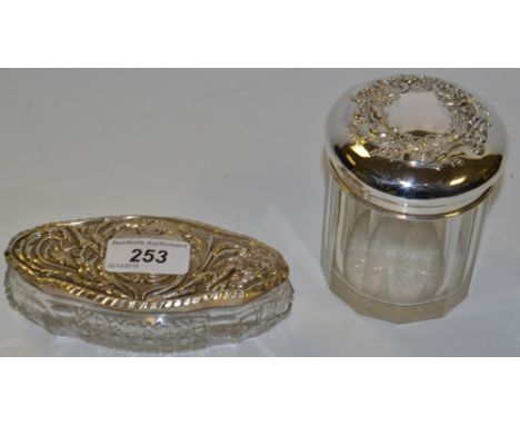 An oval dressing table box, cut glass with silver lids, Birmingham 1905 13cm x 6cm;  a dressing table jar with silver lid, Ch