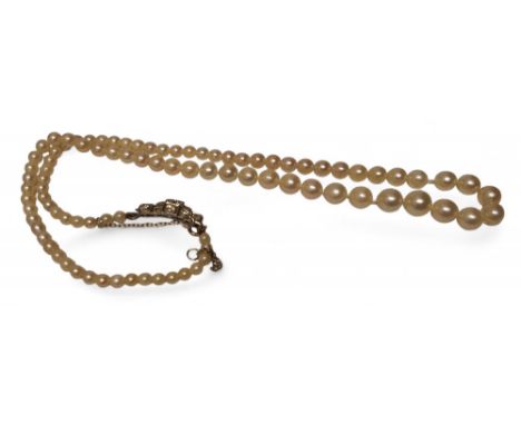 A graduated pearl necklace, the white metal Art Deco clasp set nine round diamonds, the largest being approx. 12pts, total di