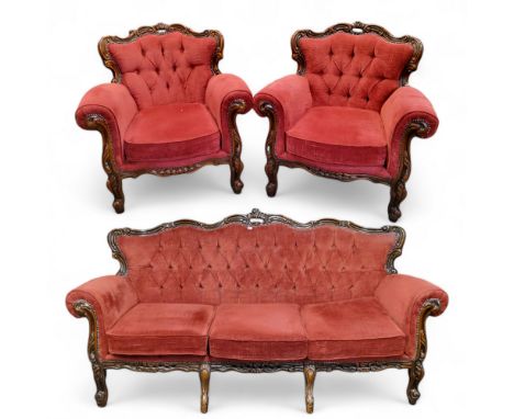 A Louis XVI style three piece salon suite, profusely carved throughout with deep buttoned back upholstery comprising of a thr
