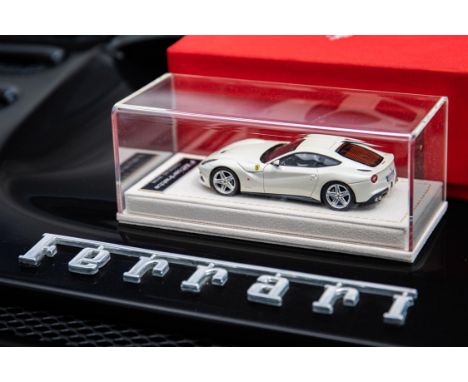 On a felt lined plinth in a Perspex box.Bespoke F12 Berlinetta model in Pearl White. 1/43 scale. In a Perspex case and fitted