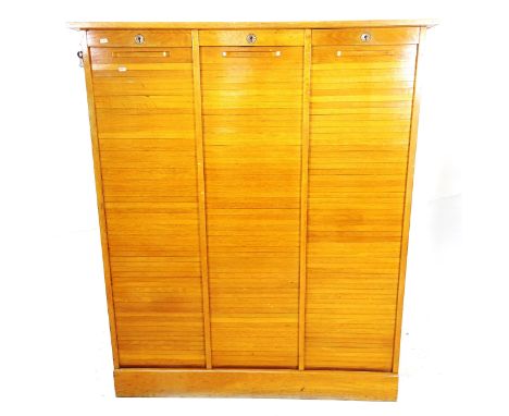 An early 20th century light oak framed 3-section tambour-front filing cabinet, W127cm, H150cm, D41cm 