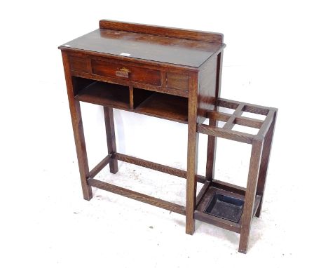 A 1930s oak hall table with integrated stick/umbrella stand, W88cm, H86cm, D31cm 