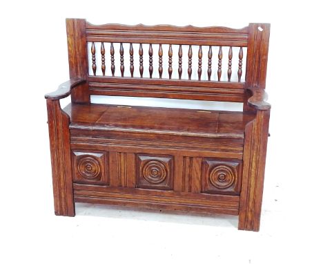 A French carved and panelled oak bench, with raised spindle back, W110cm, H99cm, D37cm 