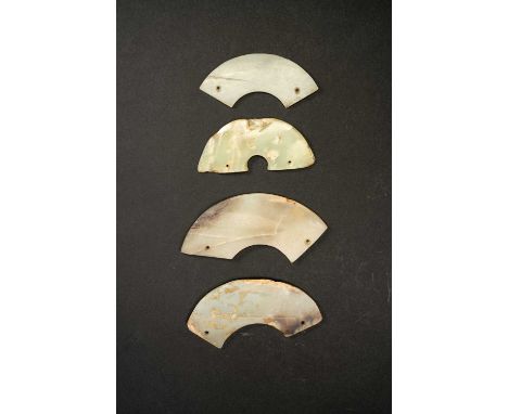 FOUR CHINESE CELADON JADE HUANGNEOLITHIC AND LATEREach formed as a curved segment, pierced with two holes, the stones varying