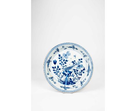 AN UNUSUAL CHINESE BLUE AND WHITE HEAVILY POTTED INSCRIBED DISHEARLY 18TH CENTURYPainted with pheasants amidst peony, the rev