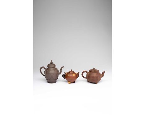 THREE CHINESE YIXING TEAPOTS AND COVERS18TH AND 19TH CENTURYOne in a darker clay with a rope twist handle, spout and knop, th