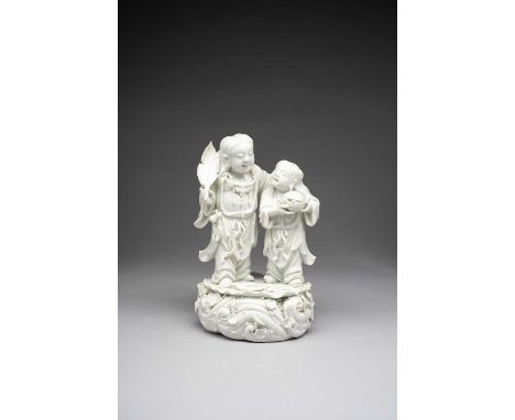 A CHINESE BLANC DE CHINE MODEL OF THE HEHE ERXIANQING DYNASTYThe twin spirits of mirth and harmony stand on a large lotus lea