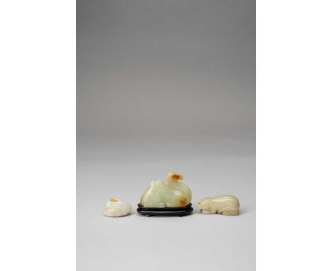 A CHINESE WHITE JADE MANDARIN DUCK AND TWO JADE ANIMAL CARVINGSQING DYNASTY OR LATERThe duck holds a lotus spray in its beak,