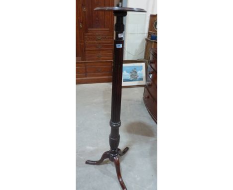 A mahogany torchere on tripod support