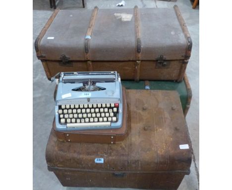 A tin trunk, two canvas trunks and two typewriters