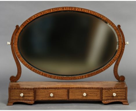 A 19th century satinwood dressing mirror
Of large proportions, the oval bevelled plate above the shaped base with four frieze