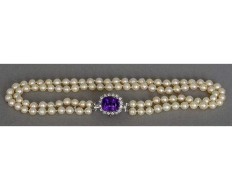 A two strand pearl necklace 
Set with an unmarked white gold or platinum, diamond and amethyst set pendant clasp.  41 cm long