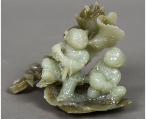 A Chinese carved jade figural group
Formed as two children before foliage.  13 cm wide. CONDITION REPORTS: Some minor frittin
