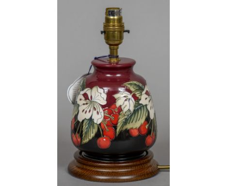 A modern Moorcroft pottery table lamp
With red ground and cherry decoration.  24 cm high. CONDITION REPORTS: Generally in goo