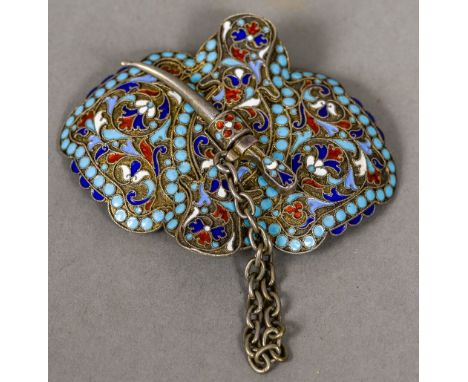 A Russian enamel decorated silver buckle
With floral scrollwork ground, the clasp formed as a dagger, stamped for 84 Zolotnik