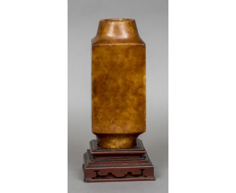 A Chinese kong vase, possibly butterscotch jade
Of double open ended form, mounted on a lacquered wooden stand.  29 cm high. 