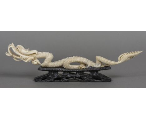 An early 20th century Chinese carved ivory model of a dragon
Modelled in full flow holding a pearl, mounted on an ebonised pi