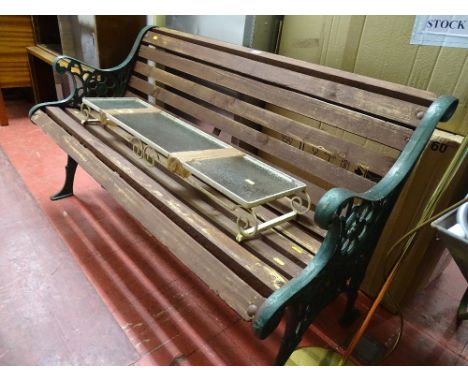 Wooden garden bench with metal ends and a small wrought iron glass topped display shelf