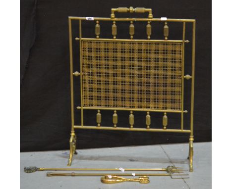 A late Victorian brass firescreen with reeded spindles, width 57cm, together with two toasting forks and a pair of coal tongs