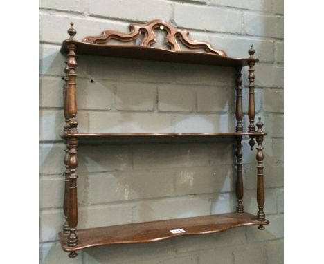 An early 20th Century mahogany three-tier bracket shelf with turned supports, height 56cm and width 51cm.