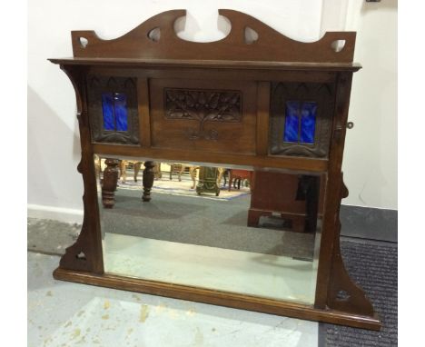 An Arts and Crafts mahogany framed overmantle mirror with pierced heart shaped detail to the frame, with shelf over a central