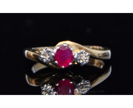 A 9ct hallmarked ruby and diamond three stone ring, central claw set rubies flanked by illusion set diamond, all to a slight 