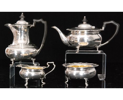 A George V hallmarked silver four piece tea service comprising hot water, teapot, sugar bowl and cream jug, each with shaped 