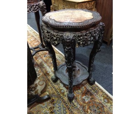 An Oriental export carved hardwood jardiniere stand with inset marble top within a carved foliate border, all over a conformi