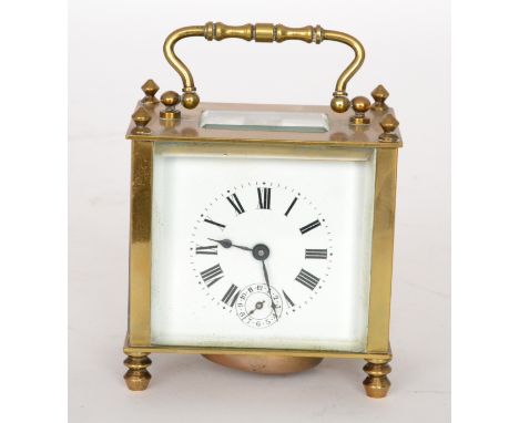 A 20th Century brass alarm carriage clock of plain form with Roman and Arabic numerals to a white enamelled dial below arched