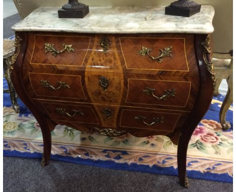 A reproduction walnut commode of bombe form in the French taste, with a grey marble top above three drawers with gilt metal m