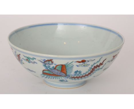 A Chinese footed bowl decorated to the exterior with stylised long tailed birds flying amidst clouds, the interior with a sim