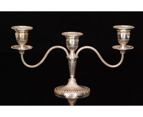 A hallmarked silver three light candelabra oval base with beaded border below twin reeded scroll arms and conforming sconces,