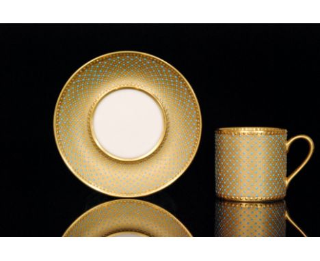 A contemporary coffee can and saucer decorated by former Royal Worcester gilder Ken Russell, the gilt ground with blue enamel