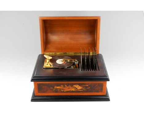 An early 21st century Reuge Music polyphon in a rectangular case with domed cover, musical emblem decoration to the cover and