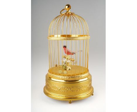 A late 20th century Reuge Music automaton bird cage of typical form, with one singing bird, on turned feet, the underside num