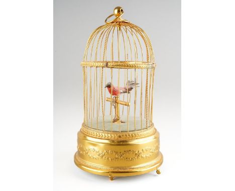 An early 20th century automaton bird cage of typical form, with one singing bird, on three short feet, in need of restoration
