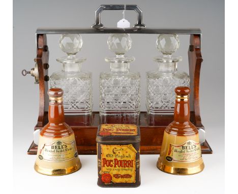 An early 20th mahogany framed  and silver plated tantalus, fitted with three square decanters with stoppers, some damage, loc