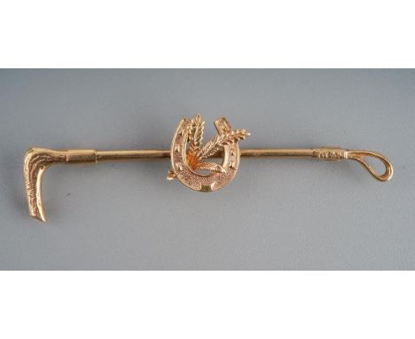 Hunting / horse interest. A 9ct gold brooch designed as a whip and a horse shoe with crop, fully hallmarked. Approx. 6 cm lon