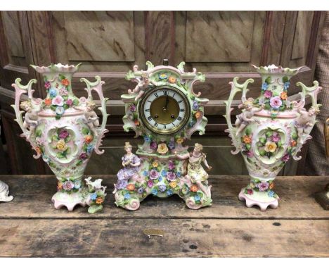 Continental porcelain clock garniture, with figural and floral decoration, enamel dial, 35cm high