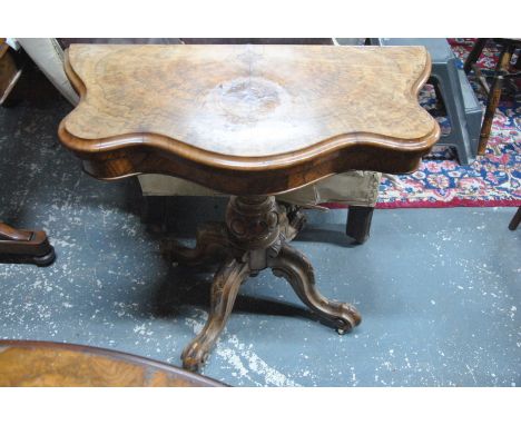 A Victorian walnut card table, the serpentine fold-over top revealing a circular baize lined surface, raised on a turned acan