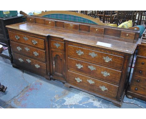 An 18th century oak low dresser, the stage back shelf with five drawers over a wide rectangular two plank top of inverted bre