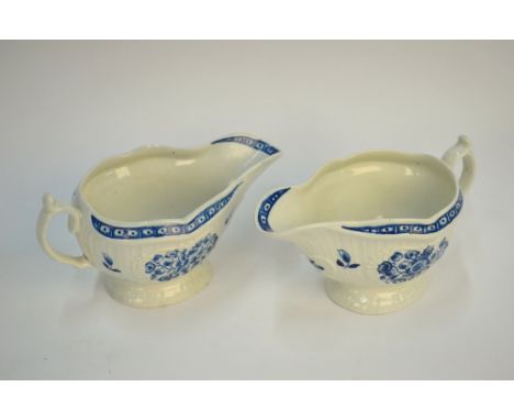 A pair of First Period Worcester strap fluted sauce boats with embossed panels painted in underglaze blue with formal sprays,