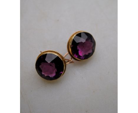 A pair of circular amethyst earrings with hook fittings for pierced ears, yellow metal setting, stamped 9ct Condition Report 